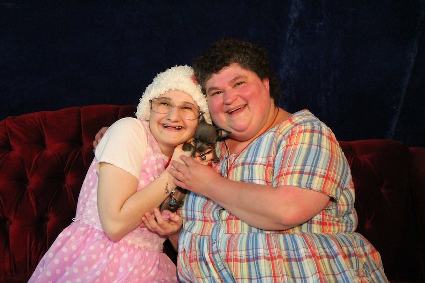 Gypsy Rose Blanchard wearing glasses hugs her mother Clauddine Blanchard as well as a small puppy