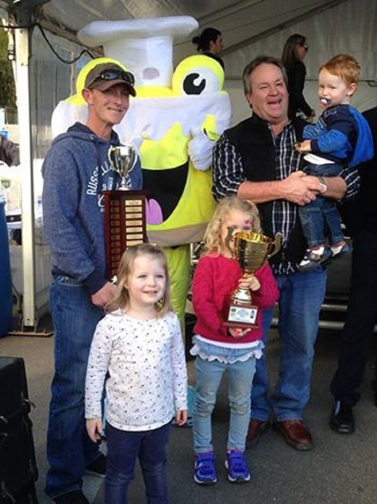 Kevin Sharp, with his son and grandchildren, holding the trophy for the best professional vanilla slice at this year's event.