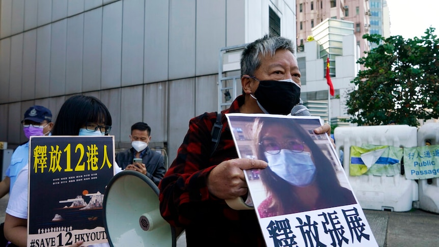 Pro-democracy activists old placards with the picture of Chinese citizen journalist Zhang Zhan as they march.