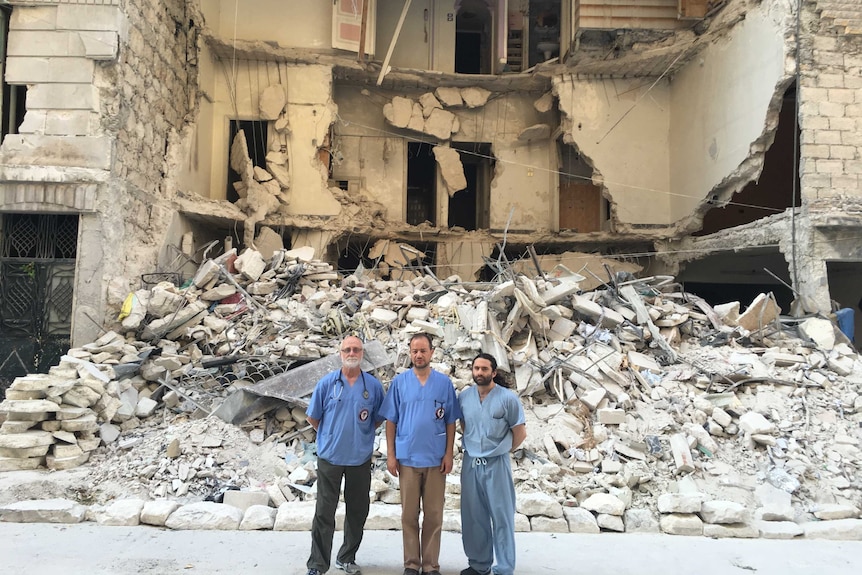 Doctors in front of rubble