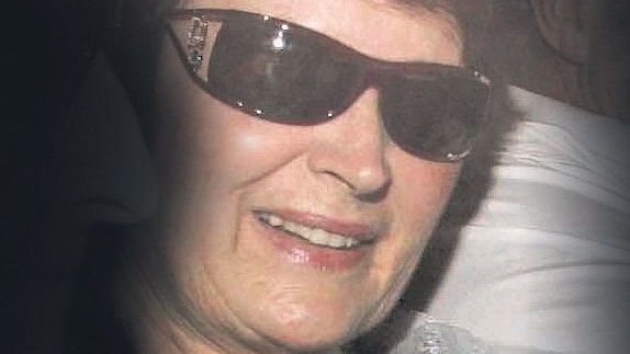A grainy photo of a woman in dark sunglasses.
