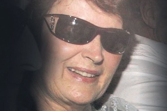 A grainy photo of a woman in dark sunglasses.