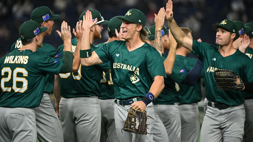 Australian baseballers celebrate with each other after a win