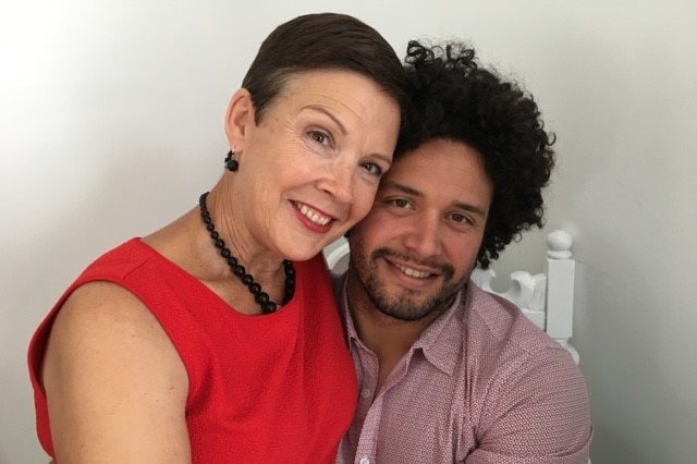 A woman and her son posse for a photo on a chair