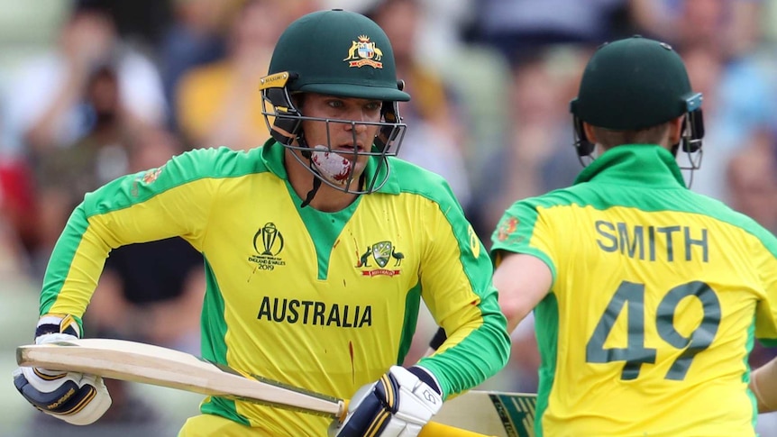 Alex Carey, with blood dripping from his bandaged chin to his shirt, runs with Steve Smith during a Cricket World Cup semi-final