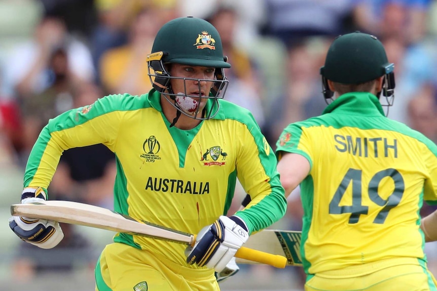 Alex Carey, with blood dripping from his bandaged chin to his shirt, runs with Steve Smith during a Cricket World Cup semi-final