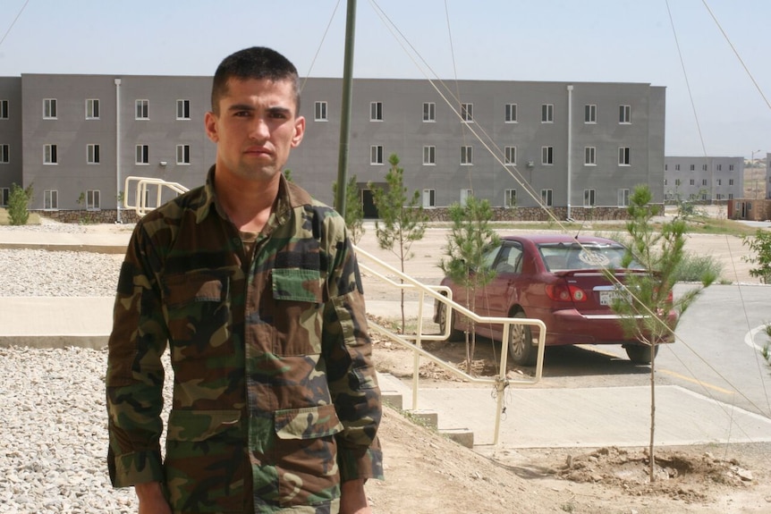 An Afghan military cadet with the new accommodation buildings of the Afghanistan National Army Officer Academy in the background.