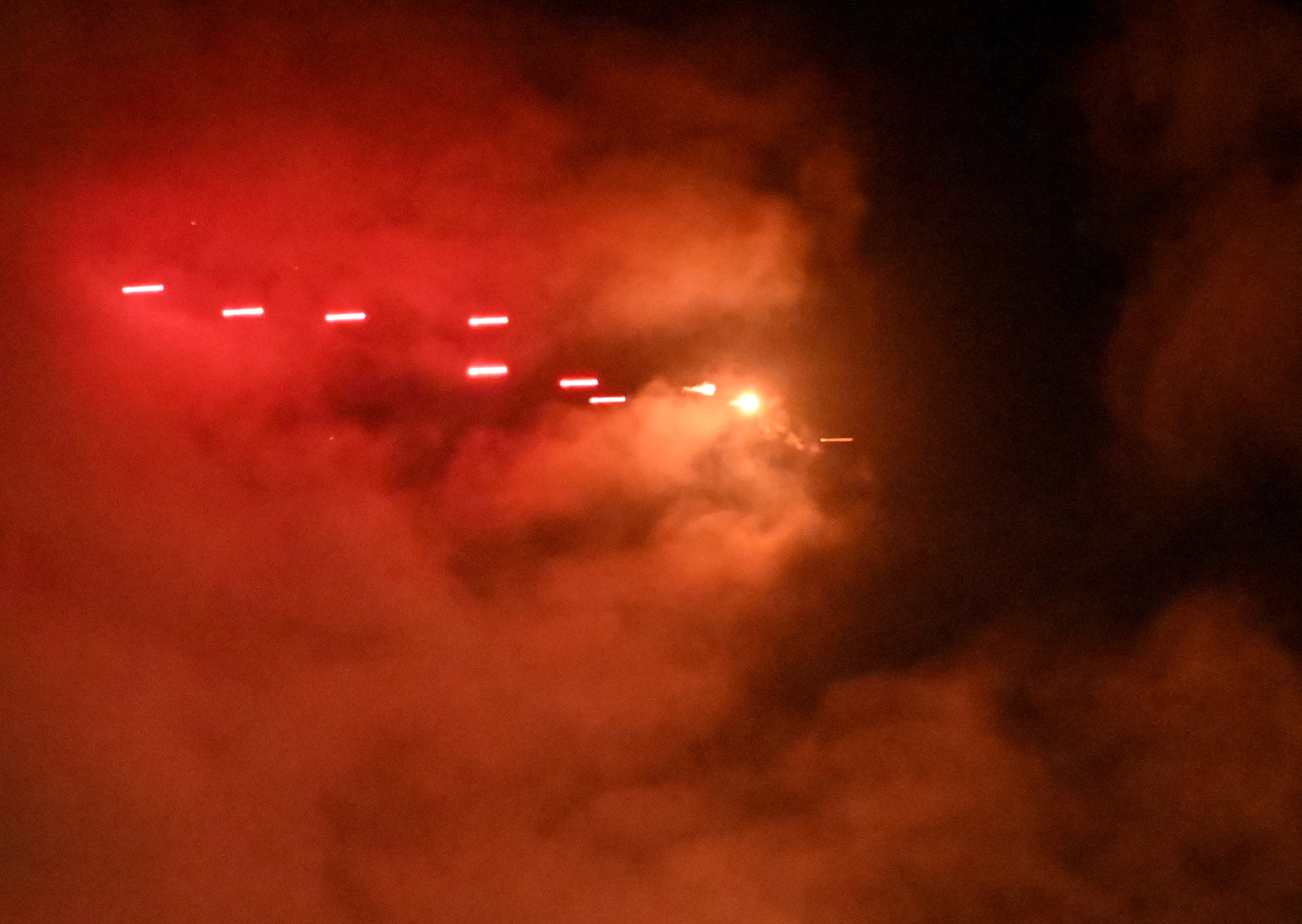 Air defence rounds in mid flight at night, flying through a cloud.