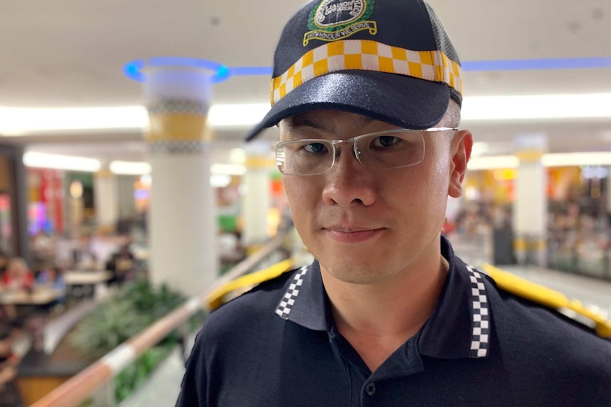 Senior Police Liaison Officer Ken Rong looks at the camera, wearing his police uniform.