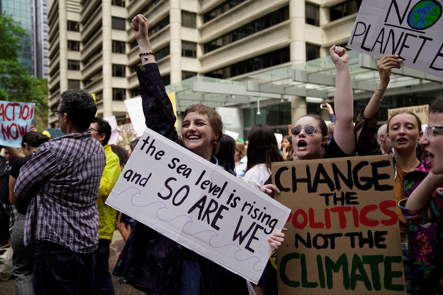 People holding signs and raising their arms in the air.