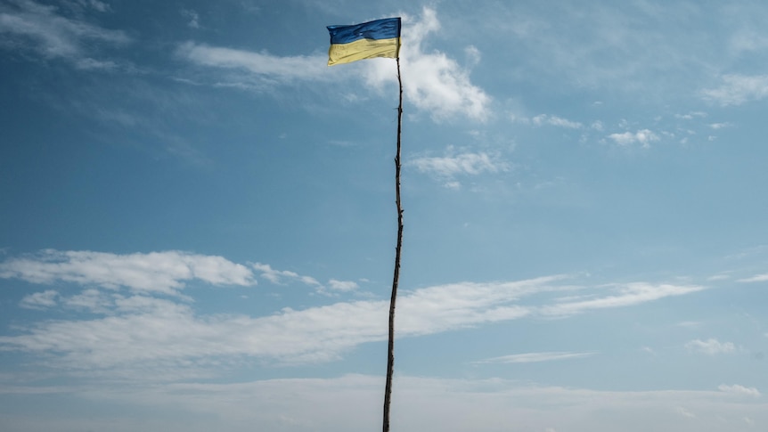 Ukrainian flag shown at the entrance of a village in the Kharkiv region