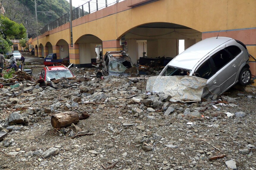 The remnants of a mudslide cover a street and cars in the village of Monterosso