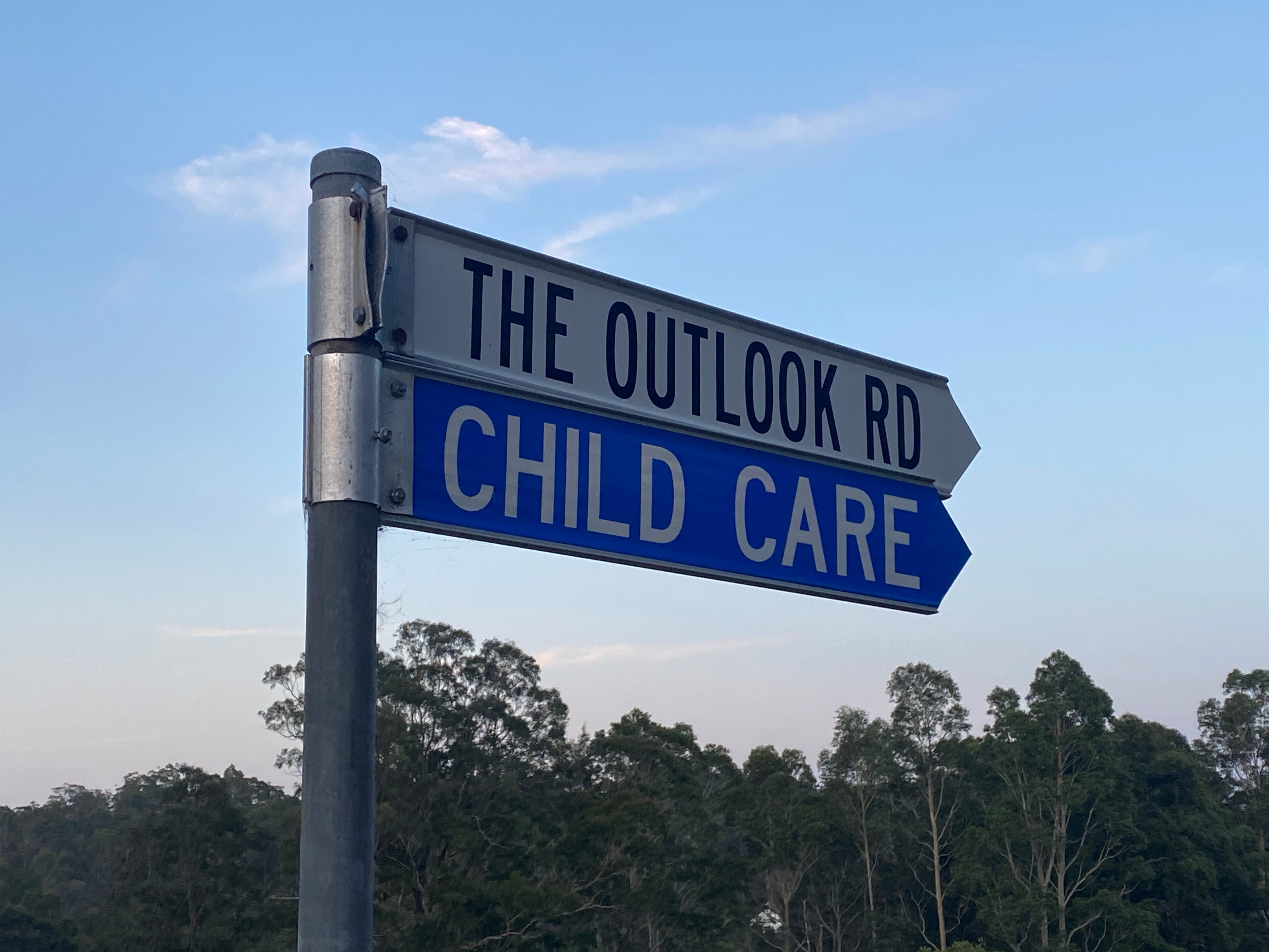 Um sinal de trânsito com sinais, estrada em perspectiva e puericultura.