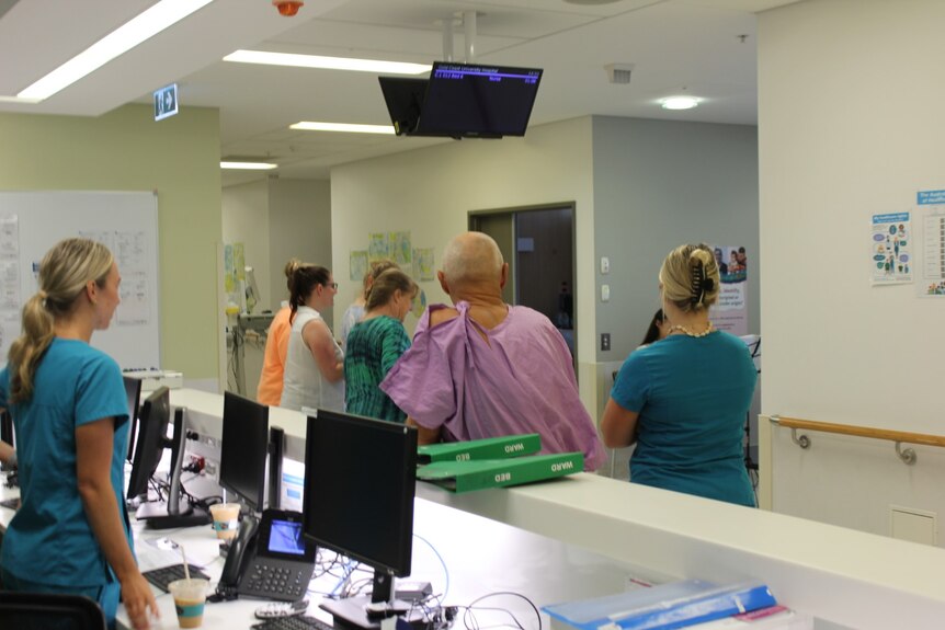People in a hospital watch a string quartet performing.