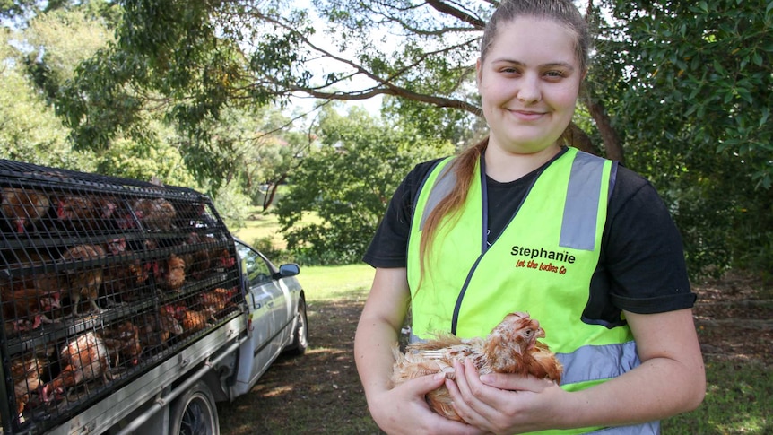 Woman holding a sick-looking chicken.