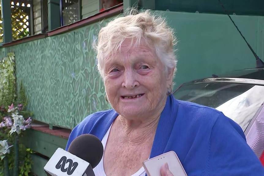an older woman speaking into a TV microphone 