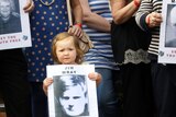 A young girl holds a picture of one of those killed in the Bloody Sunday shootings.
