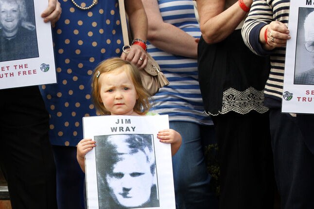A young girl holds a poster