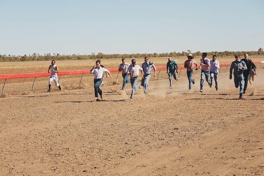 Men running on an outback race track.