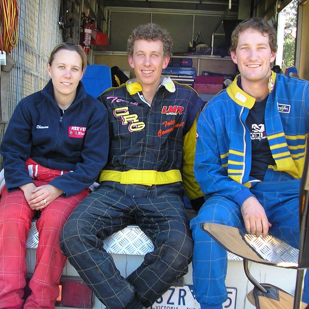 Mlada žena i dva mladića u sportskim majicama, sjedeći zajedno na stražnjem dijelu kamiona.