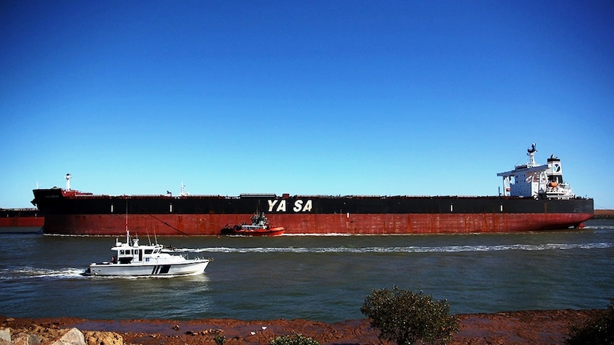 A tug assists a ship entering port