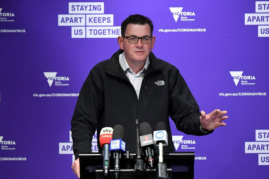 Daniel Andrews frowns and puts his hand up during a press conference