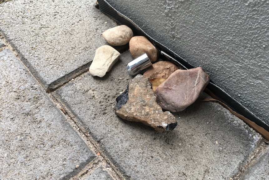 A pile of rocks next to a house on a path