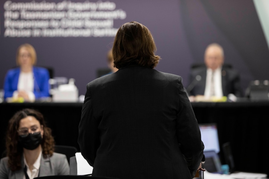 A woman stands up and addresses commissioners.