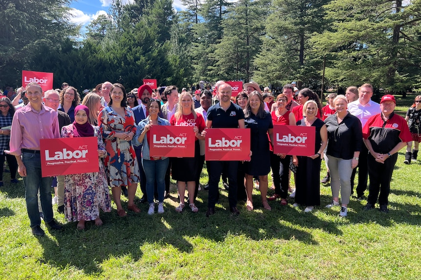A large group of people standing together with signs that say Labor.