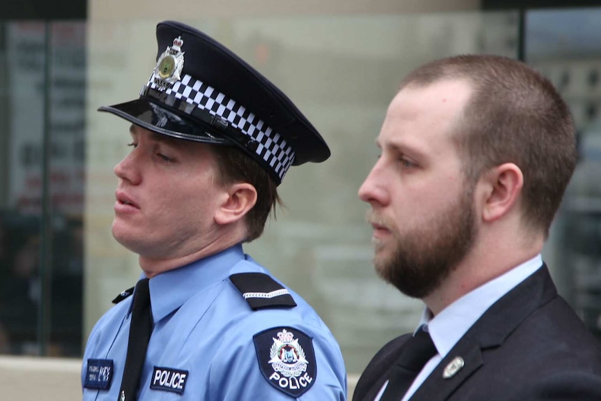 First Class constable Tom Gryta and an unknown man standing outside court