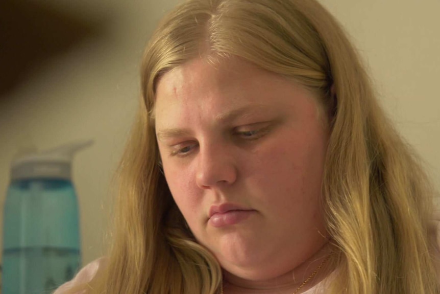 Tight head shot of Chloe Tomlinson in a pink top looking down slightly