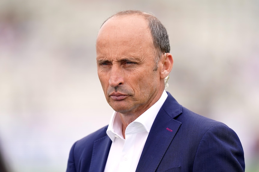 Nasser Hussain looks on with a stern expression on his face, wearing a suit