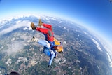 Tandem skydivers parachuting over a city