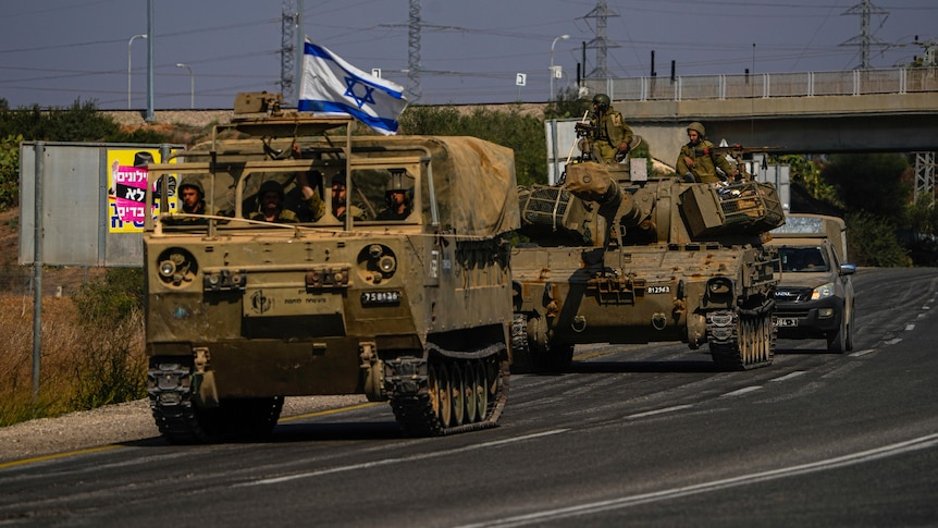 Israeli troops in tanks ride on highway road 