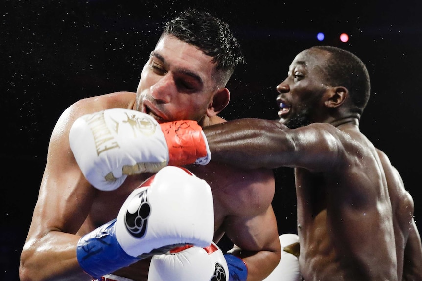 Sweat flies off Amir Khan as he is punched in the face by Terence Crawford during their WBO welterweight title fight.