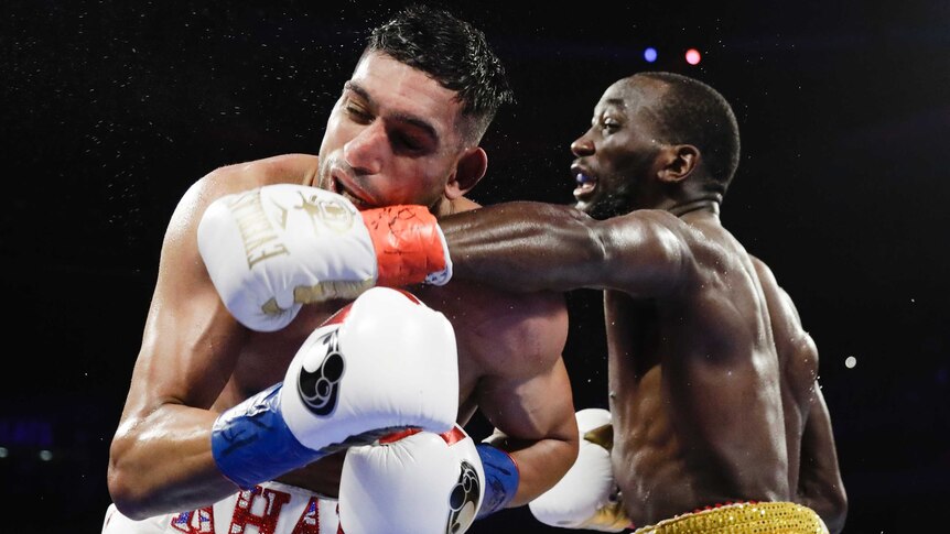 Sweat flies off Amir Khan as he is punched in the face by Terence Crawford during their WBO welterweight title fight.