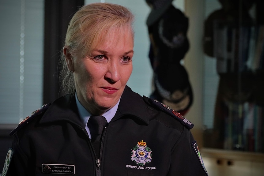 A woman in a police uniform sitting at a police station. 