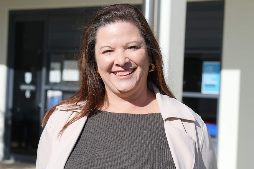 woman with brown hair smiles at camera