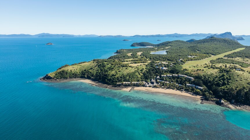 Pictured from the sky Lindeman Island surrounded by turquoise water.  