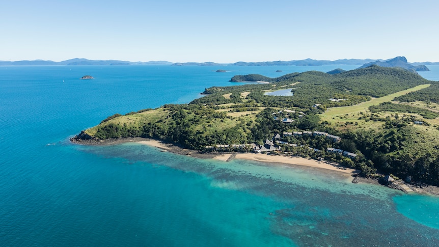 Pictured from the sky Lindeman Island surrounded by turquoise water.  