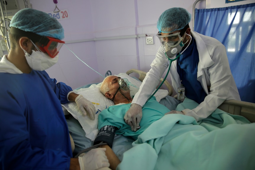 Medical workers attend to a COVID-19 patient in an intensive care unit at a hospital in Sanaa, Yemen.