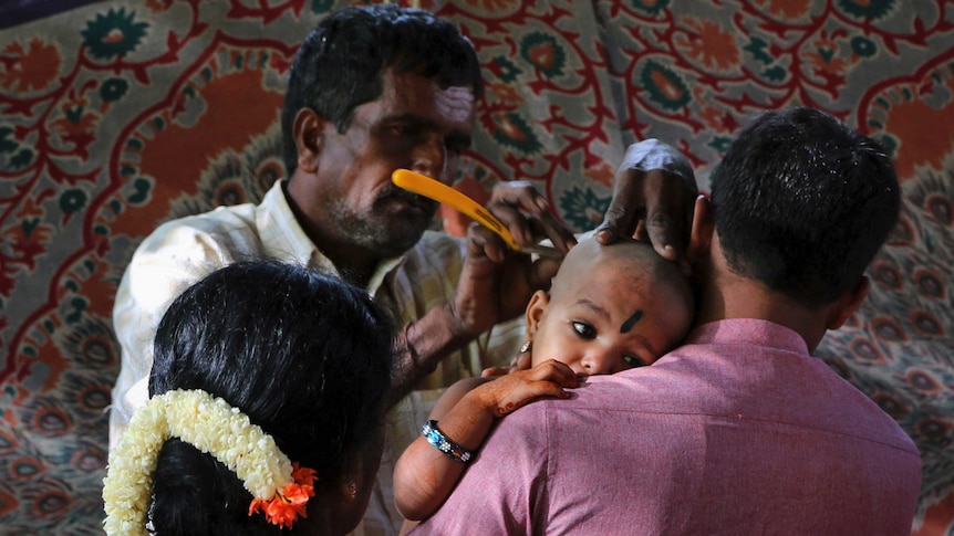 Devotees of Hindu God Muruga get the head of their child shaved.