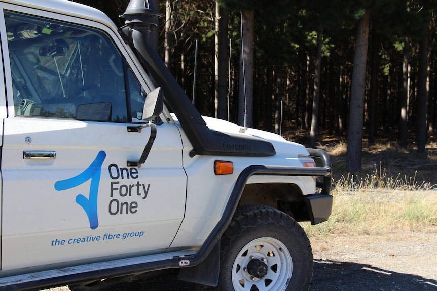 A car with "One Forty One" branding with a plantation behind