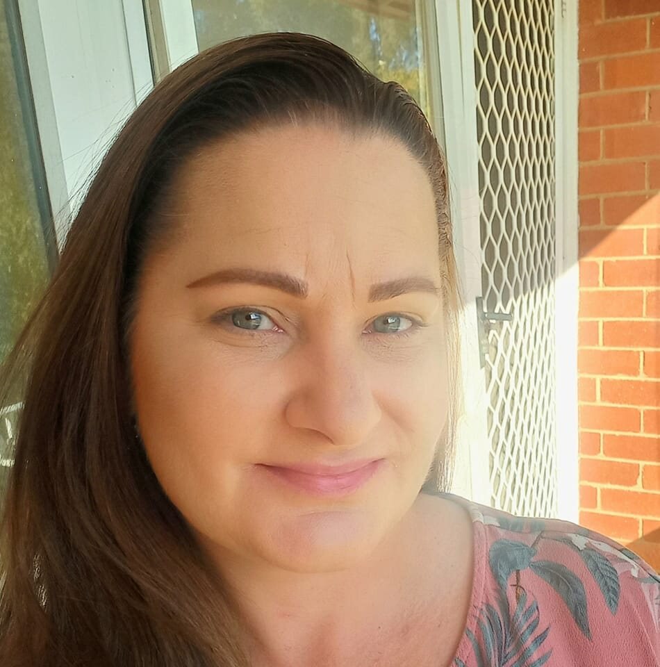  a woman with dark hair and blue eyes looks at the camera for a selfie