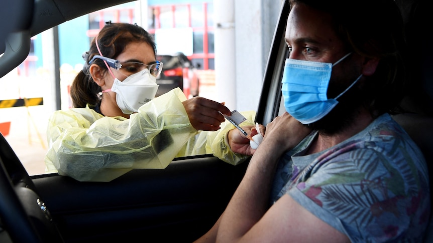 A resident receives a dose of the Pfizer Covid-19 vaccine in Australia's first drive through vaccination centre
