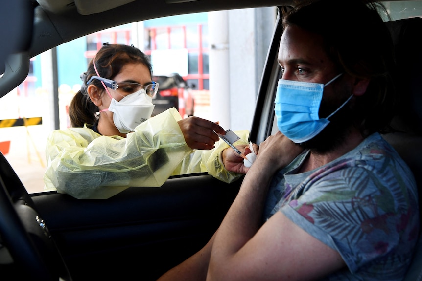 A resident receives a dose of the Pfizer Covid-19 vaccine in Australia's first drive through vaccination centre