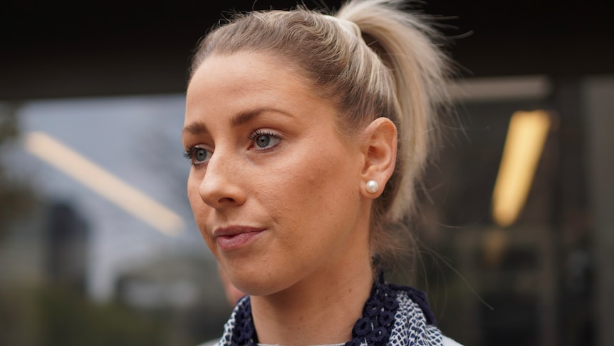 A close up of a woman with blonde hair in a ponytail