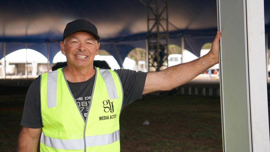 Tent designer Tony Gasser is leaning against one of the poles holding up the tent
