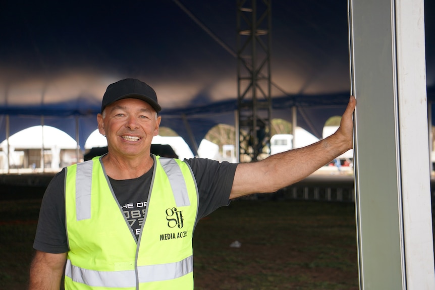 Tent designer Tony Gasser is leaning against one of the poles holding up the tent