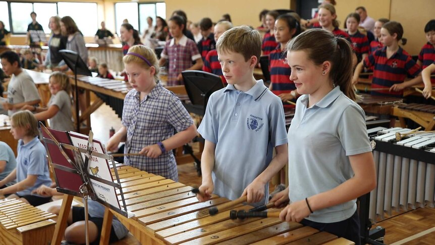 A room full of students playing marimbas